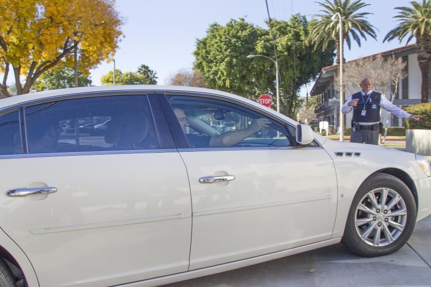 Federal officials drive Enrique Marquez, backseat, to the Riverside Federal Courthouse to be criminally charged in connection with the San Bernardino terrorist attack.