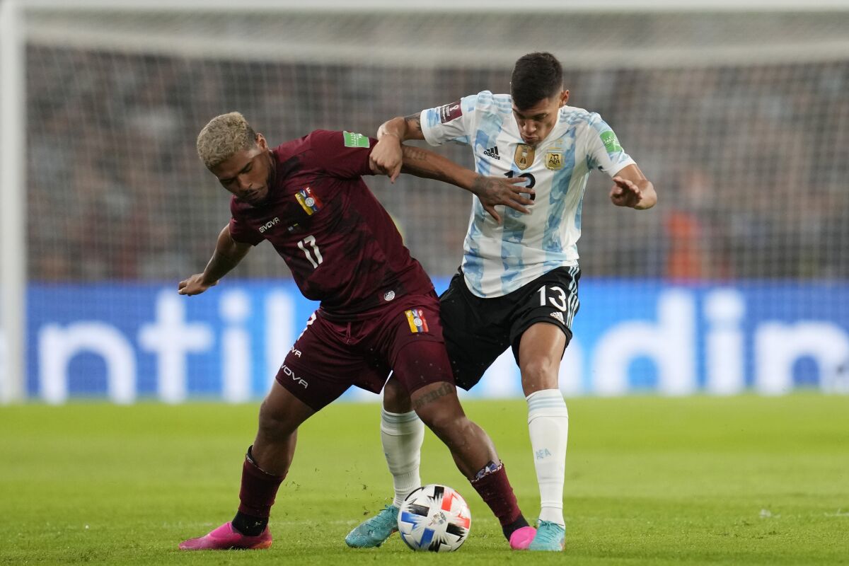 Venezuela's Josef Martinez, left, and Argentina's Nahuel Molina battle for the ball during a qualifying soccer match for the FIFA World Cup Qatar 2022, at the Bombonera stadium in Buenos Aires, Argentina, Friday, March 25, 2022.(AP Photo/Natacha Pisarenko)