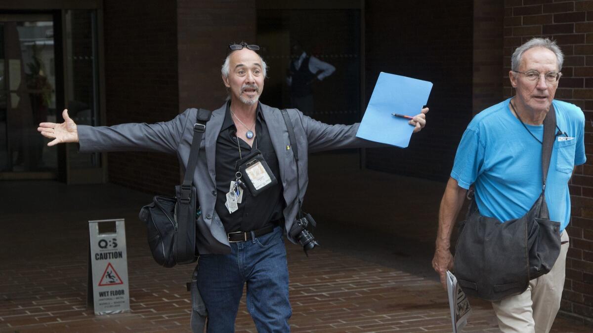 New York Daily News staff photographers Todd Maisel, left, and Andrew Savulich walk out of the newspaper's office Monday after being laid off.