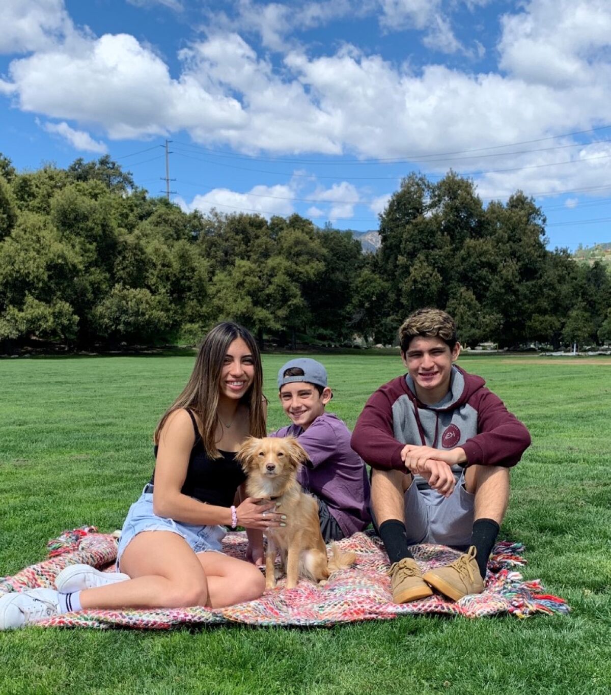 Maddie, left, Greyson and Jakob Torres, with their foster pup, Benny.