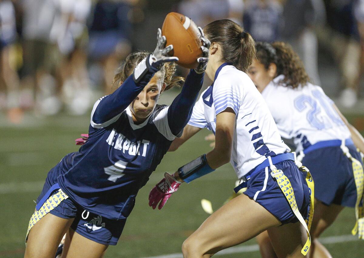 Newport Harbor's Kate Kubiak (4) lunges for a first down after a catch in the girls' flag football Battle of the Bay game.