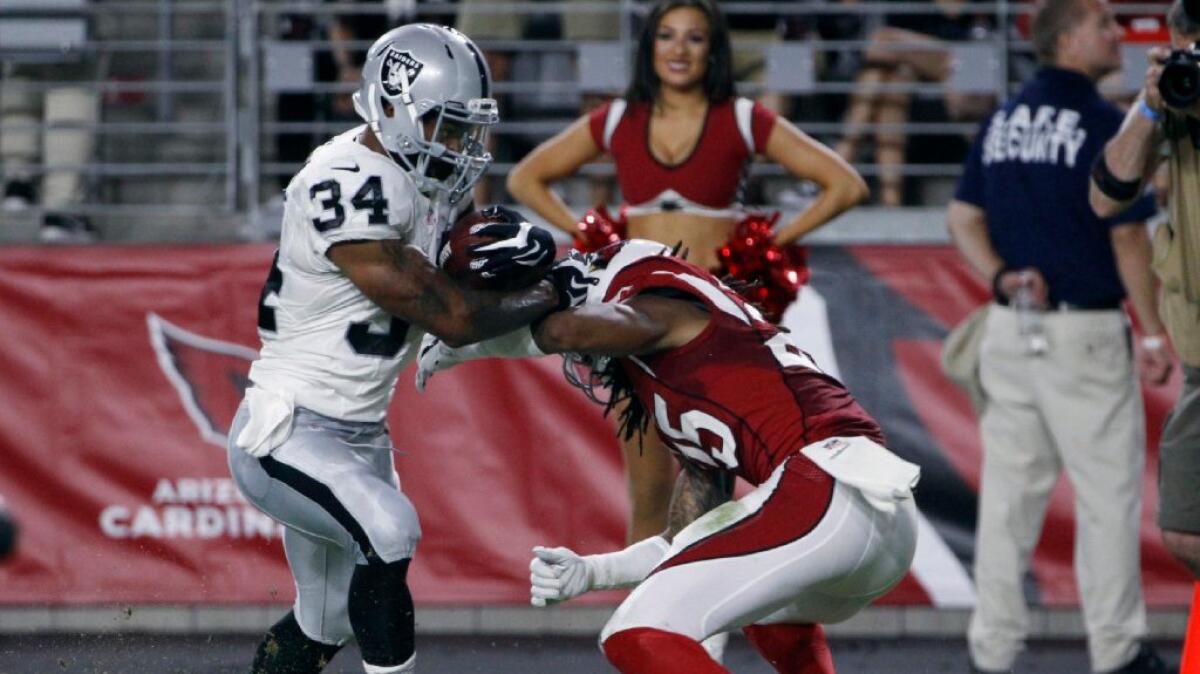 Raiders running back George Atkinson III (34) brushes aside Cardinals defensive back Marqui Christian on a touchdown run a game on Aug. 12.