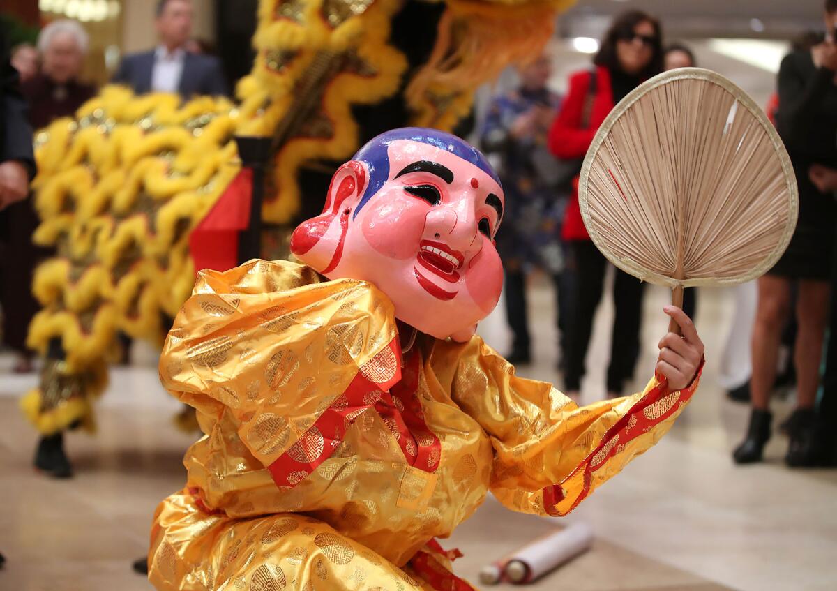 A traditional Lion Dancer in a monk mask entertains during the Lunar New Year celebration.