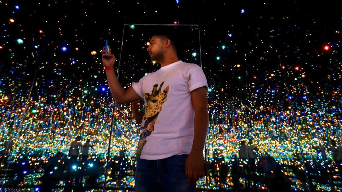 Scott Reyes, 26, of Los Angeles stands inside Yayoi Kusama's "Infinity Mirrored Room -- The Souls of Millions of Light Years Away" at the Broad.