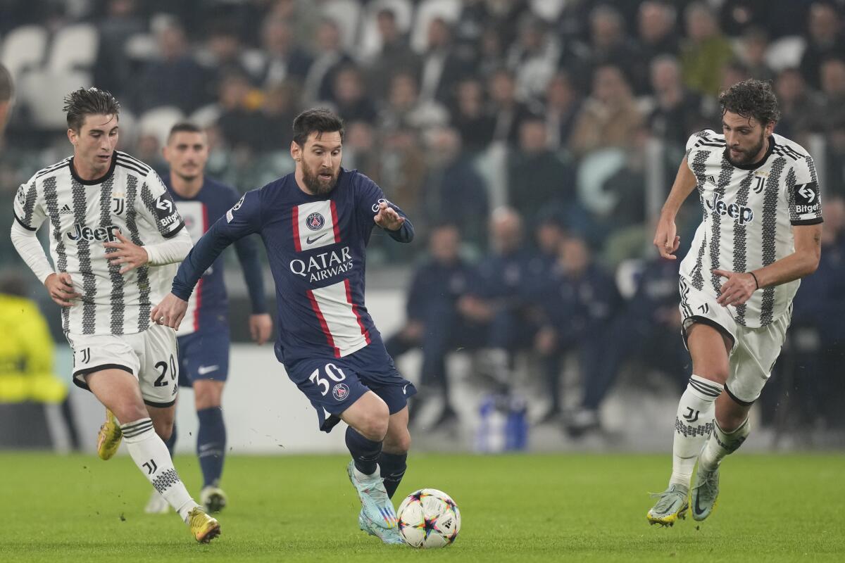 PSG's Lionel Messi runs with the ball past Juventus' Manuel Locatelli and Fabio Miretti.