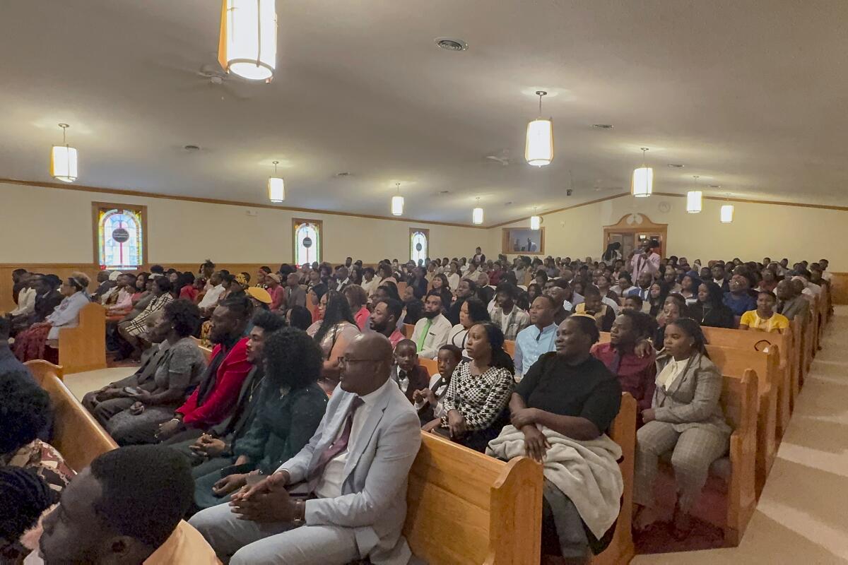 People sit in a crowded church.