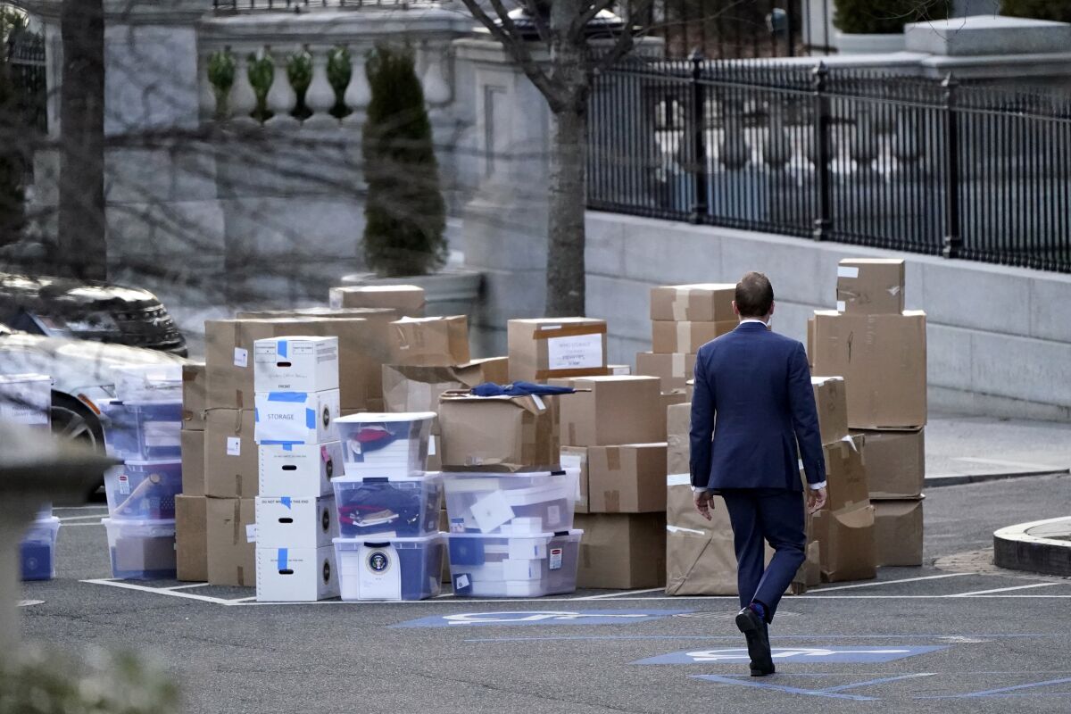 FILE - A man walks past boxes that were moved out of the Eisenhower Executive Office building, just outside the West Wing, inside the White House complex, Thursday, Jan. 14, 2021, in Washington. The State Department says it's unable to compile a complete accounting of gifts presented to U.S. officials by foreign governments during the final year of the Trump administration due to missing White House data. (AP Photo/Gerald Herbert, File)