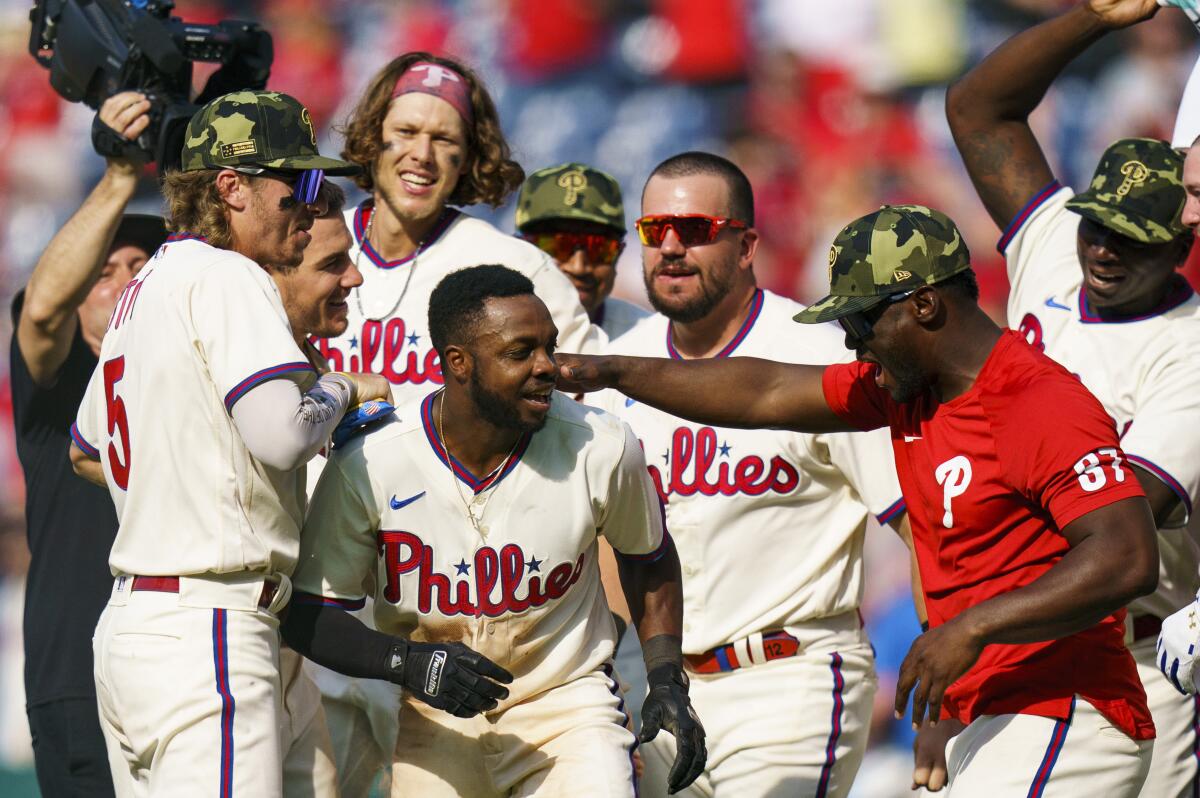 Philadelphia's Roman Quinn celebrates with teammates after scoring the winning run.