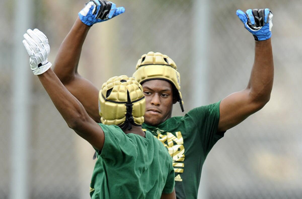 Long Beach Poly receiver John Smith celebrates with a teamate after catching a touchdown pass against Serra during the Edison passing tournamnet last summer.