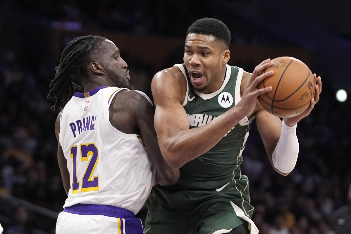 Lakers forward Taurean Prince gets physical with Bucks forward Giannis Antetokounmpo as he tries to drive to the basket.