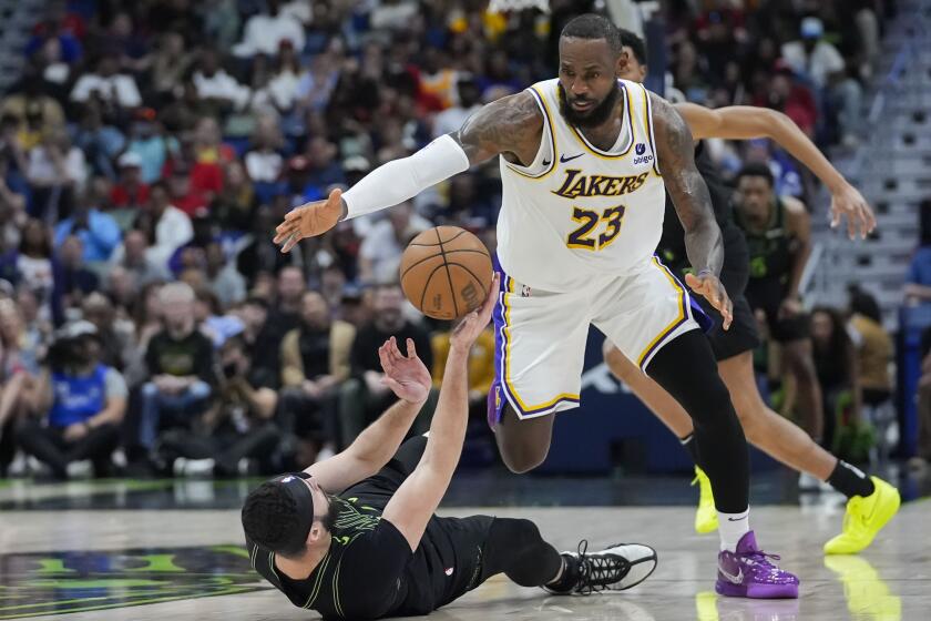 Los Angeles Lakers forward LeBron James (23) moves to steal the ball from fallen New Orleans Pelicans forward Larry Nance Jr.