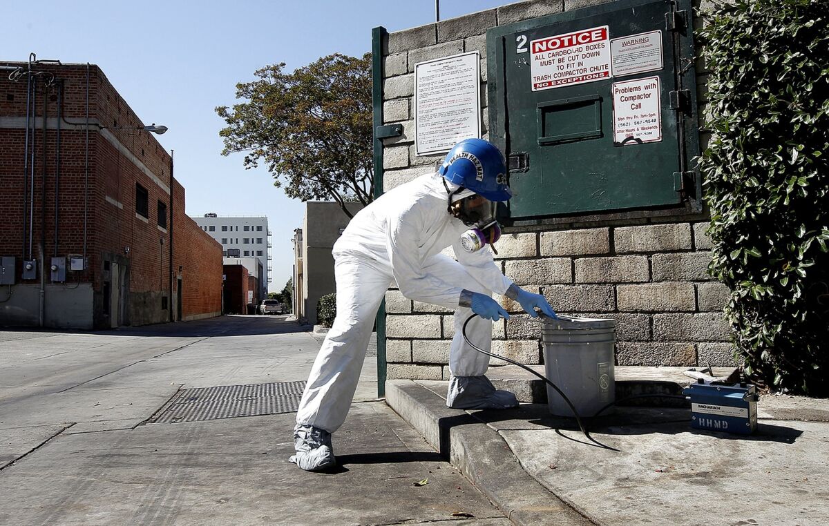 Los Angeles County Fire Department hazardous materials specialist Mario Benjamin inspects an abandoned container in an alley in Whittier in August. After the chemicals are identified, appropriate pickup is arranged.
