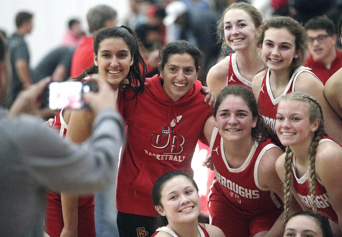 Burroughs' head coach Vicky Oganyan smiles with her team during a team photo after defeating Whittier Christian in the CIF Southern Section Division II-A girls' basketball quarterfinal at Whittier Christian High School in La Habra on Wednesday, February 19, 2020. Burroughs won the game 41-39, a game that was hard fought until the last points were scored