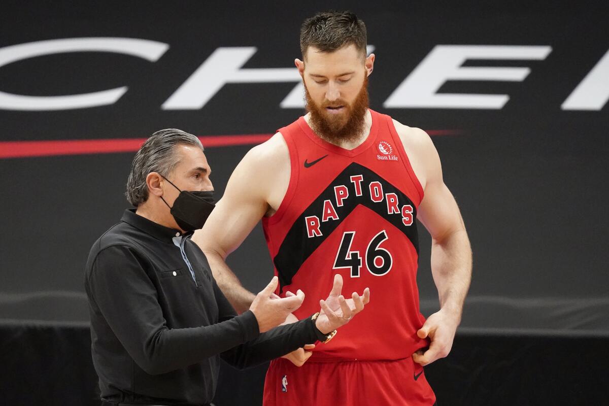 El entrenador asistente de los Raptors de Toronto Sergio Scariolo charla con el centro Aron Baynes (46).