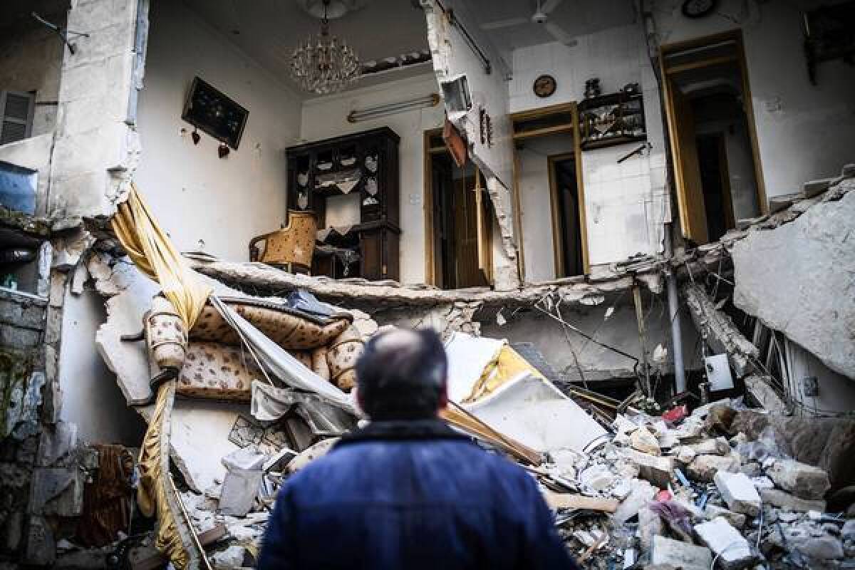 A resident looks at a destroyed home in Aleppo, Syria. The ongoing violence has left some Syrians feeling walled in by the two opposing sides in the conflict.