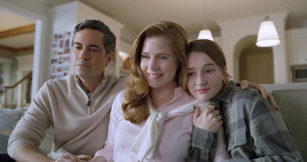 The movie's Murphy family, huddled on a couch, played by Danny Pino, Amy Adams and Kaitlyn Dever.