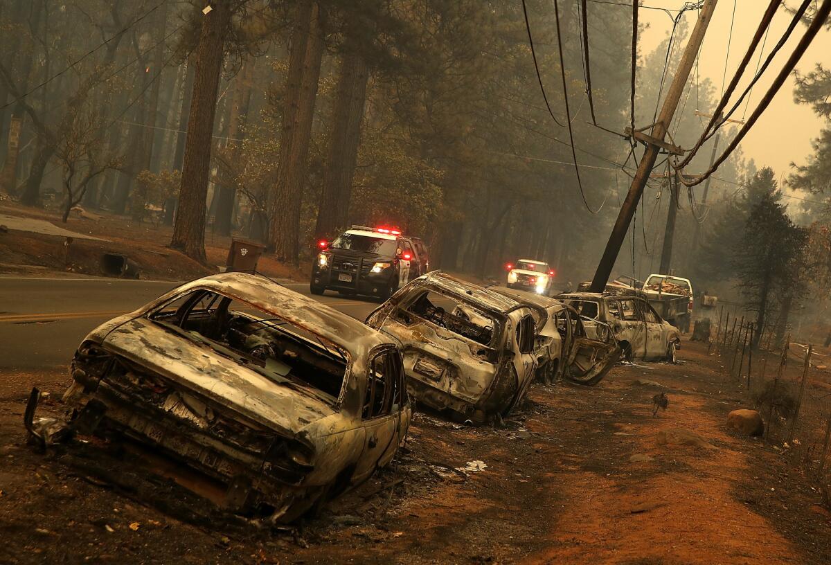 Burned-out abandoned cars sit on the road after the Camp fire moved through the area.