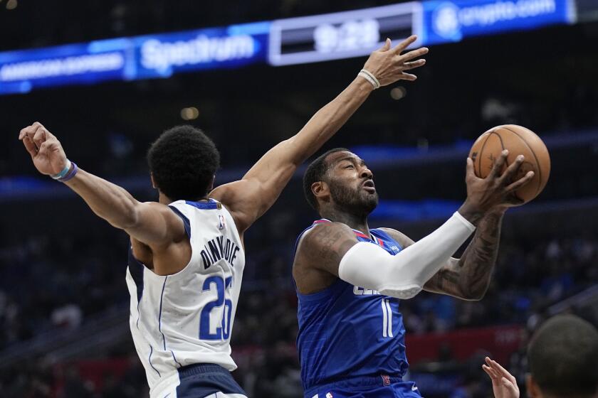 Los Angeles Clippers guard John Wall, right, shoots as Dallas Mavericks guard Spencer Dinwiddie defends during the second half of an NBA basketball game Tuesday, Jan. 10, 2023, in Los Angeles. (AP Photo/Mark J. Terrill)