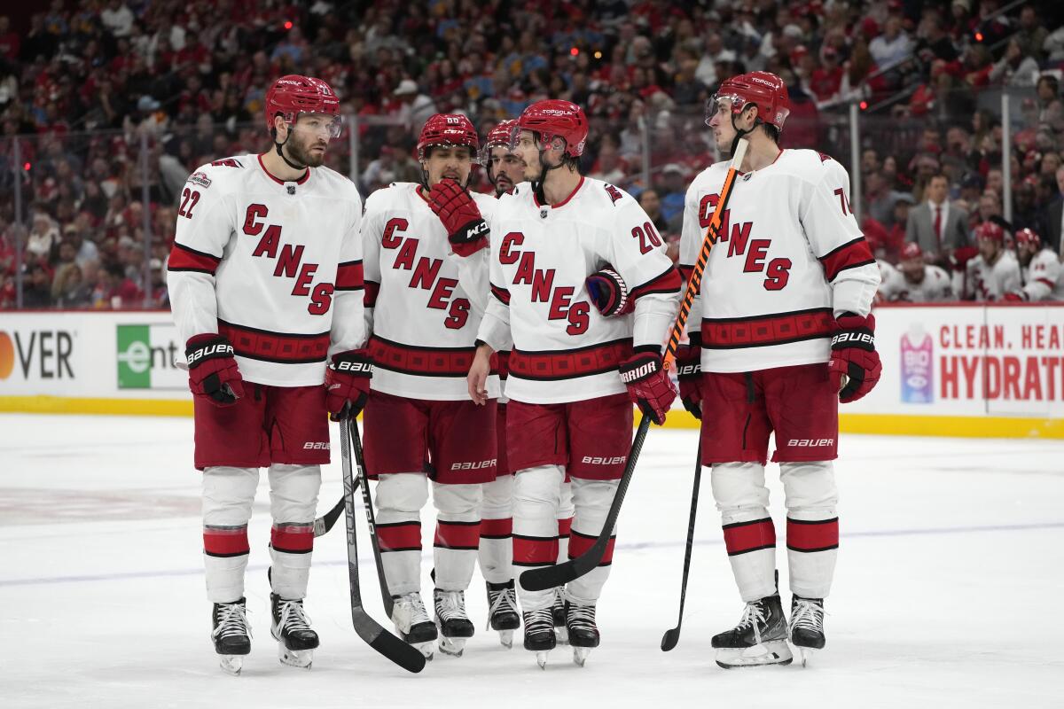 Carolina Hurricanes players talk during a break in the third period of Game 4 of the NHL hockey Stanley Cup Eastern Conference finals against the Florida Panthers, Wednesday, May 24, 2023, in Sunrise, Fla. (AP Photo/Wilfredo Lee)