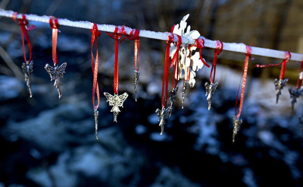 Angel pendants in memory of the schoolchildren killed at Sandy Hook Elementary hang from a snow-covered string in Newtown, Conn.