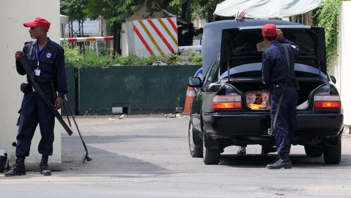 Security guards check a vehicle outside the U.S. consulate in Lahore, Pakistan.