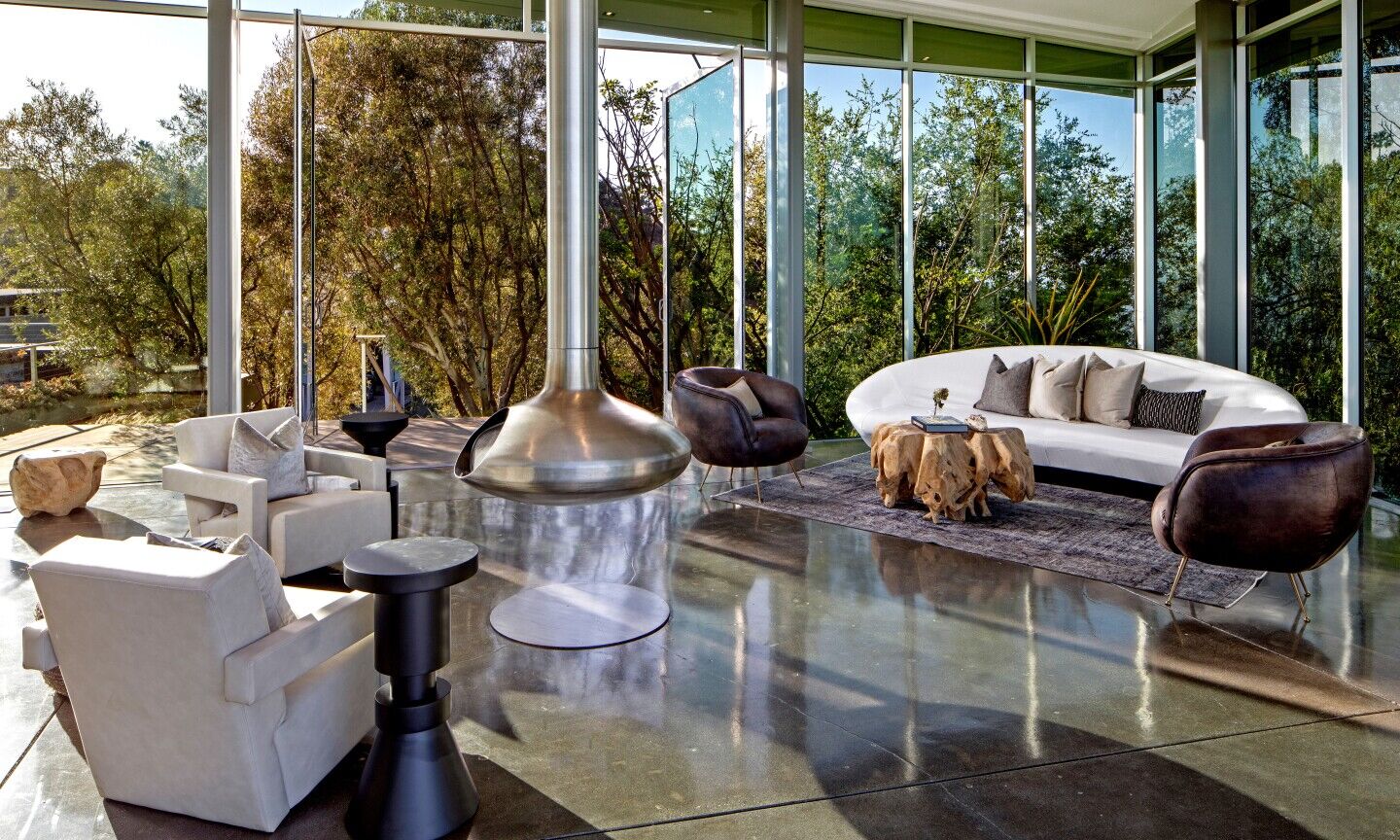 The fireplace is in the middle of the room surrounded by furniture.