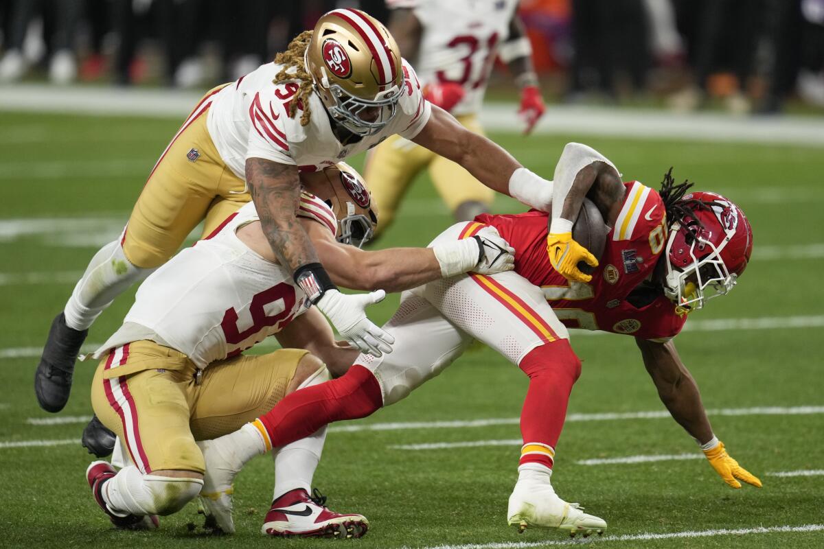 Chiefs running back Isiah Pacheco is tackled by San Francisco 49ers defensive end Nick Bosa and defensive end Chase Young.