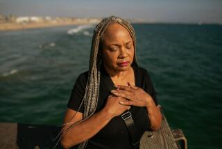 Los Angeles, CA - June 03: With her hands clasped over her heart, Deneen Vaughn takes a moment to reflect on her son Chris who died by suicide on Saturday, June 3, 2023 in Los Angeles, CA. Vaughn stands on the Venice Beach pier at the location where she and her family released the ashes their loved one. (Jason Armond / Los Angeles Times)