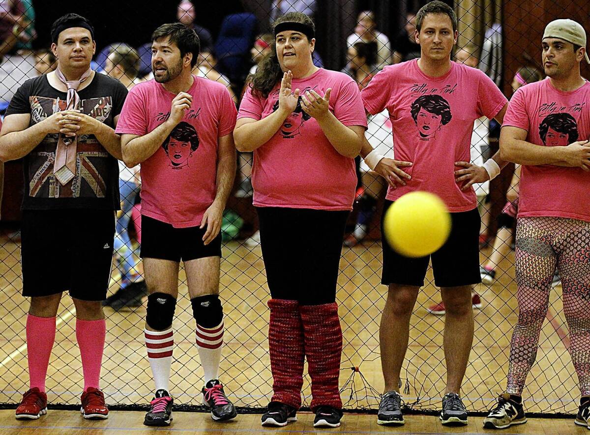 Jake Mason, second from left, an organizer of the WeHo Dodgeball League, watches from the sidelines as his team, Pretty in Pink, competes.