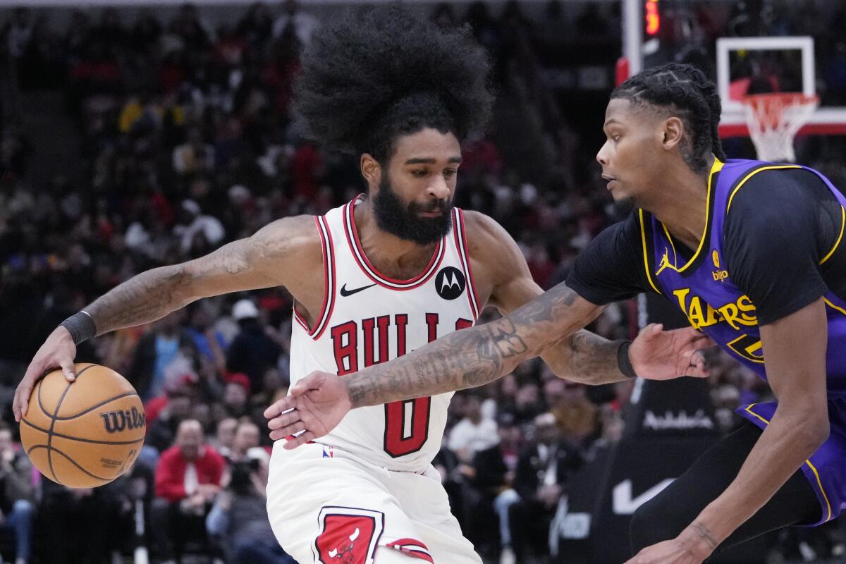 Bulls guard Coby White drives against Lakers forward Cam Reddish in the second half.