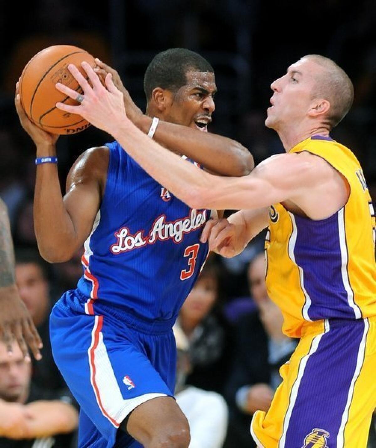 Steve Blake tries to steal the ball away from Chris Paul during the Lakers' home opener against the Clippers at Staples Center on Tuesday.