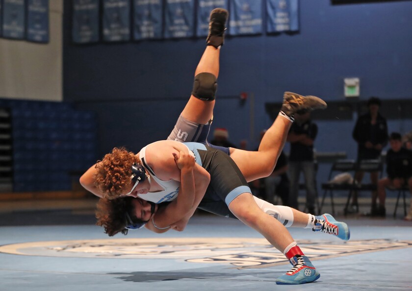 Corona del Mar's Anthony Leon throws Newport Harbor's Nick Ibarra to the mat during the Battle of the Bay wrestling match.