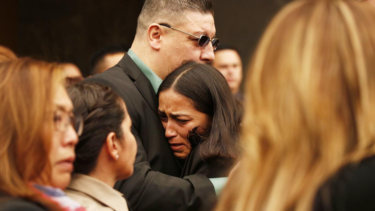 Sheriff's Deputy Joseph Solano's stepdaughter Jessica Jimenez is comforted by Solano's childhood friend, Daniel Ramos.