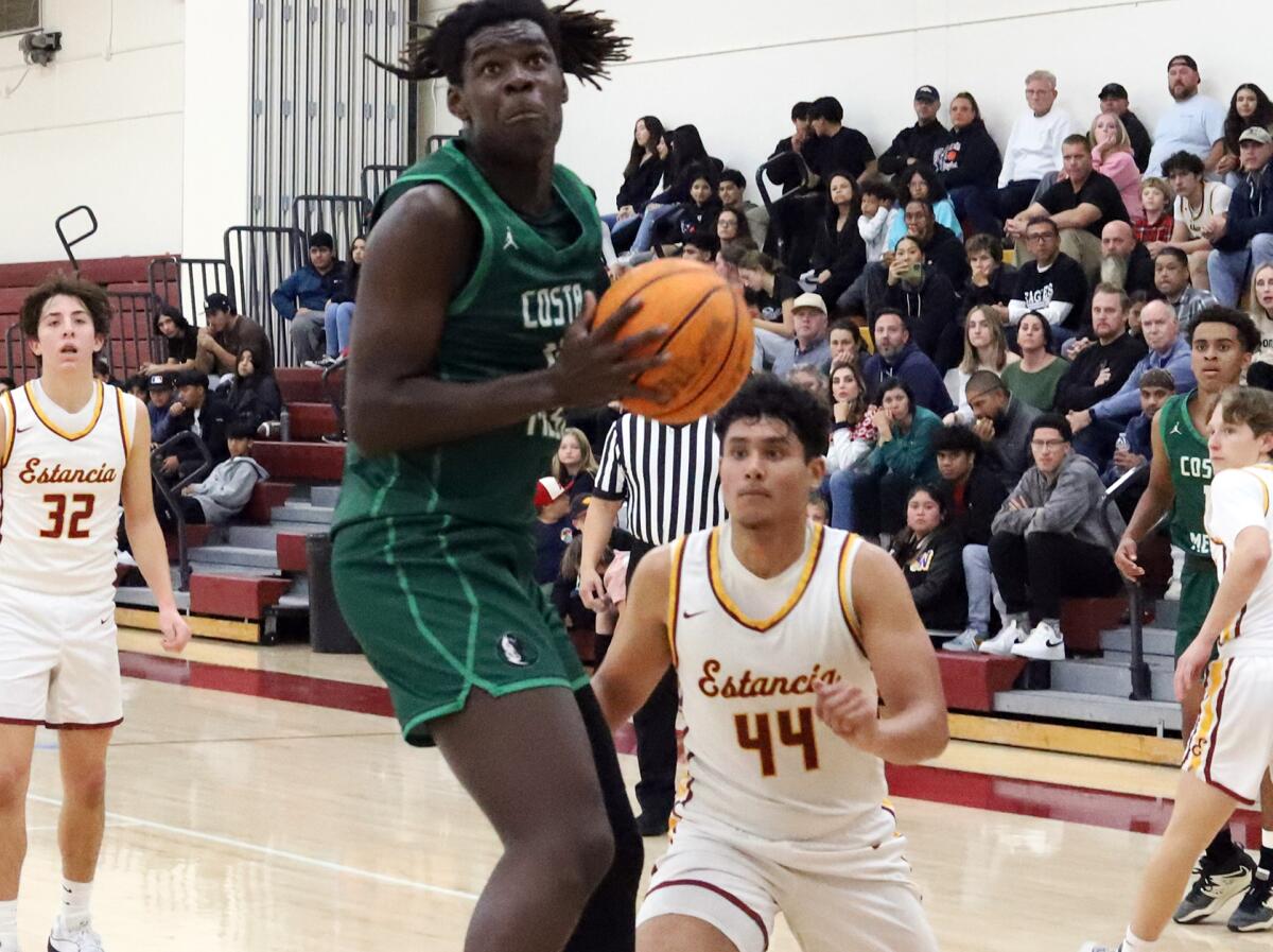 Costa Mesa's Kembe Howerton (11) grabs an offensive rebound against Estancia on Friday night.