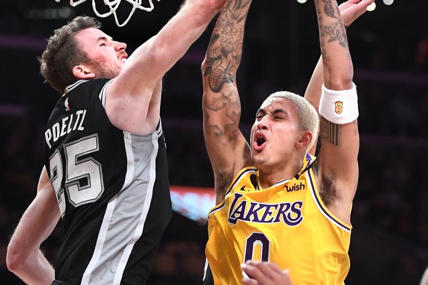 Kyle Kuzma is fouled by the Spurs' Jakob Poeltl while driving to the basket during the fourth quarter of a game Feb. 4 at Staples Center.
