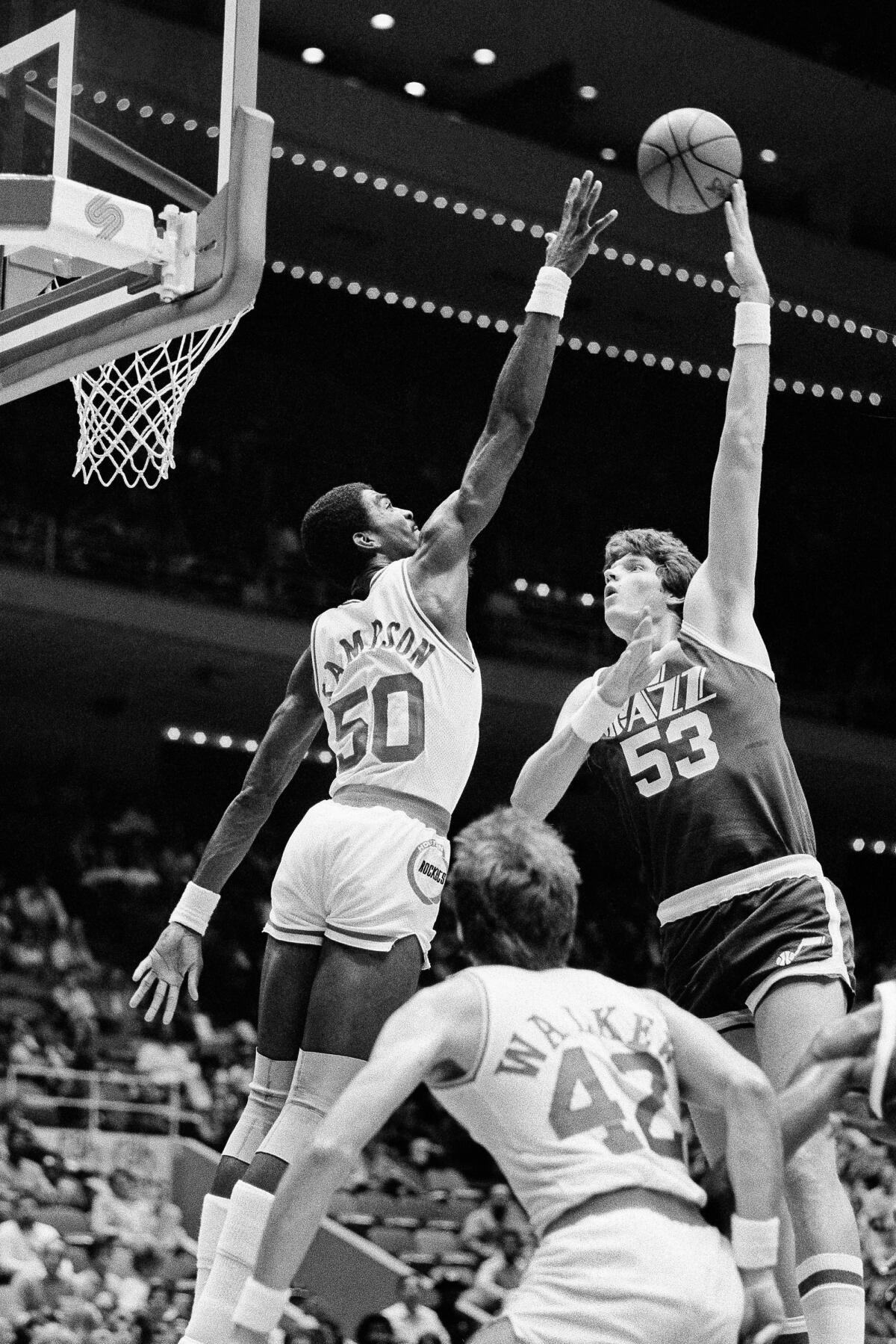 Jazz center Mark Eaton attempts a hook shot over Rocket center Ralph Sampson.