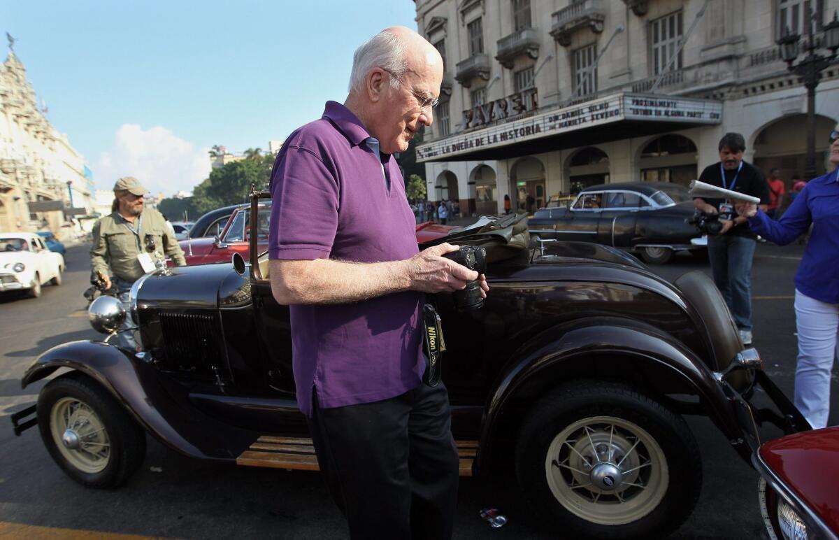 Sen. Patrick J. Leahy (D-Vt.) takes pictures of old vehicles outside National Capitol building in Havana, Cuba.
