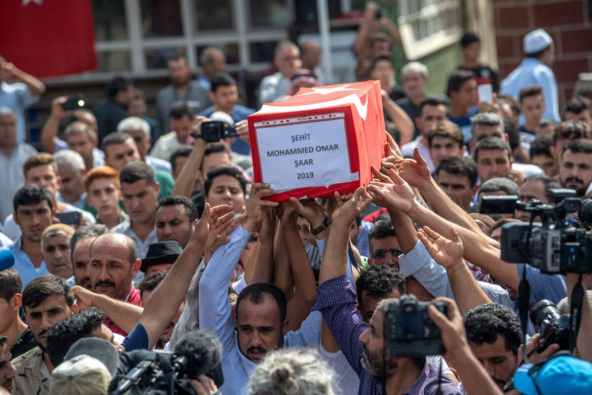 An infant's coffin is carried in Akcakale. 