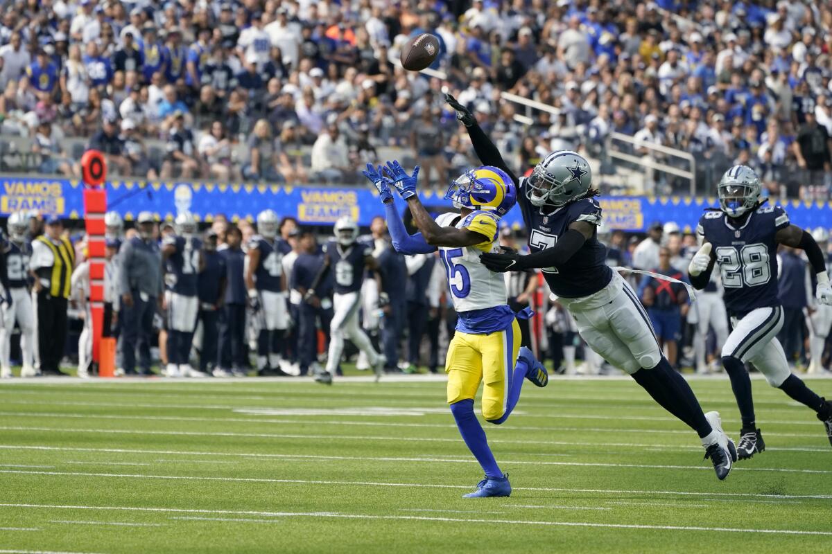 Rams wide receiver Tutu Atwell (15) catches a 54-yard pass in front of Cowboys cornerback Trevon Diggs.