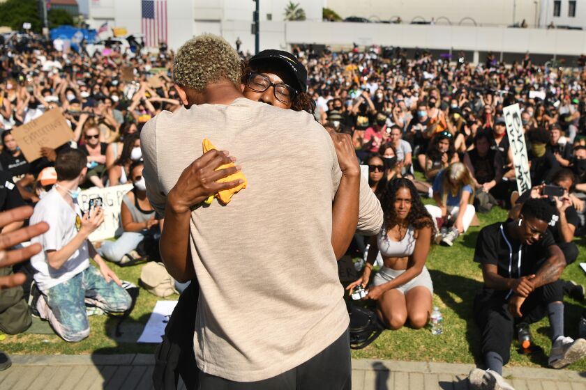 BEVERLY HILLS, CALIFORNIA JUNE 6, 2020-A family member of Breonna Taylor, right, is hugged by another woman after speaking to protestors in Beverly Hills Saturday. The protest was organzied by the Refuse Fascism group. (Wally Skalij/Los Angeles Times)