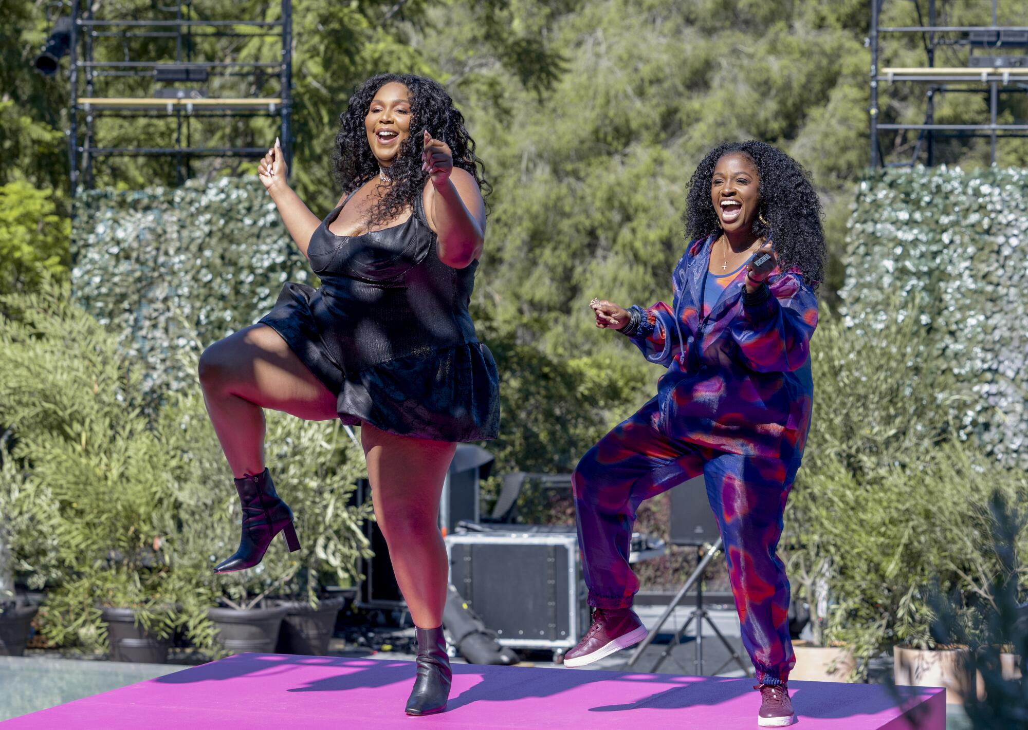 Two women dance on an outdoor stage