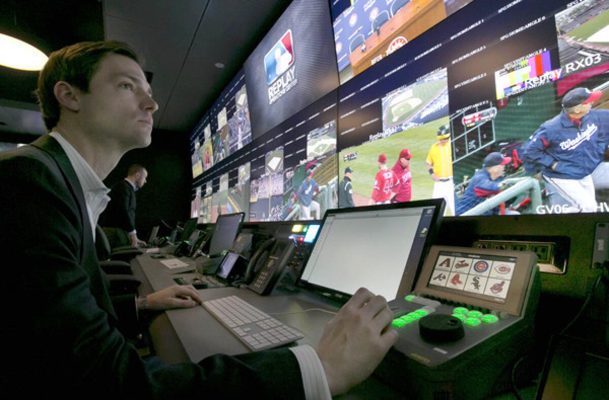 Chris Marinak sits in front of a bank of television screens at the replay operations center for Major League Baseball in New York.