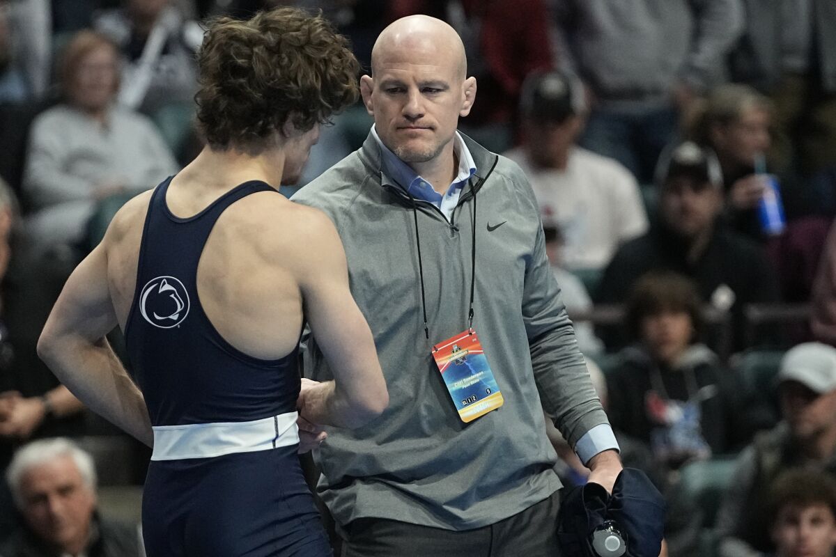 Penn State head coach Cael Sanderson, right, consoles Levi Haines after Haines was defeated by North Carolina's Austin O'Connor in the 157 lb. championship match the NCAA Wrestling Championships, Saturday, March 18, 2023, in Tulsa, Okla. (AP Photo/Sue Ogrocki)