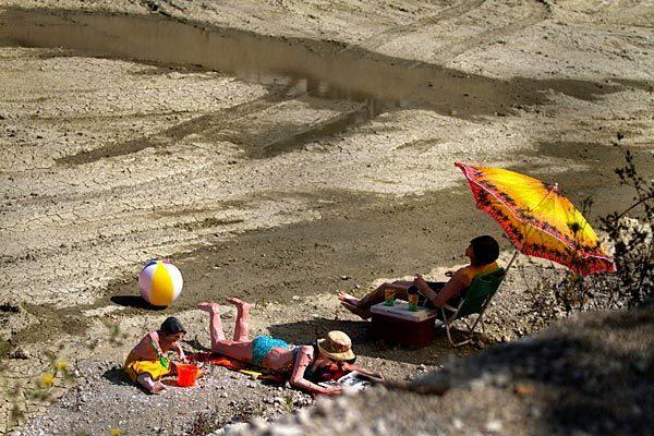 A papier-mache family sunbathes in a dirt pit on Broadway and 1st Street in downtown L.A. Street artist Calder Greenwood and his partner, only known as Wild Life, installed the sculptures there in May to call attention to the unnoticed.