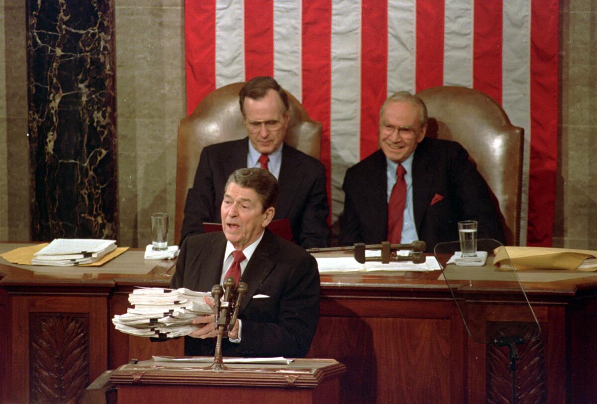 President Ronald Reagan holds up a 14-pound continuing resolution for the budget, part of a total package weighing 43-pounds, during his 1988 State of the Union address.