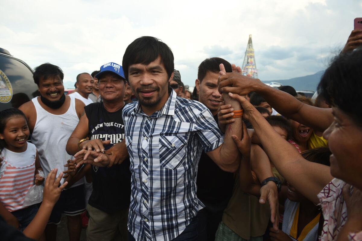 Retired boxer and Philippine Congressman Manny Pacquiao greets supporters during a campaign stop in Laguna province on Thursday. The nation's president said a militant group had wanted to kidnap Pacquiao, who is running for a Senate seat.