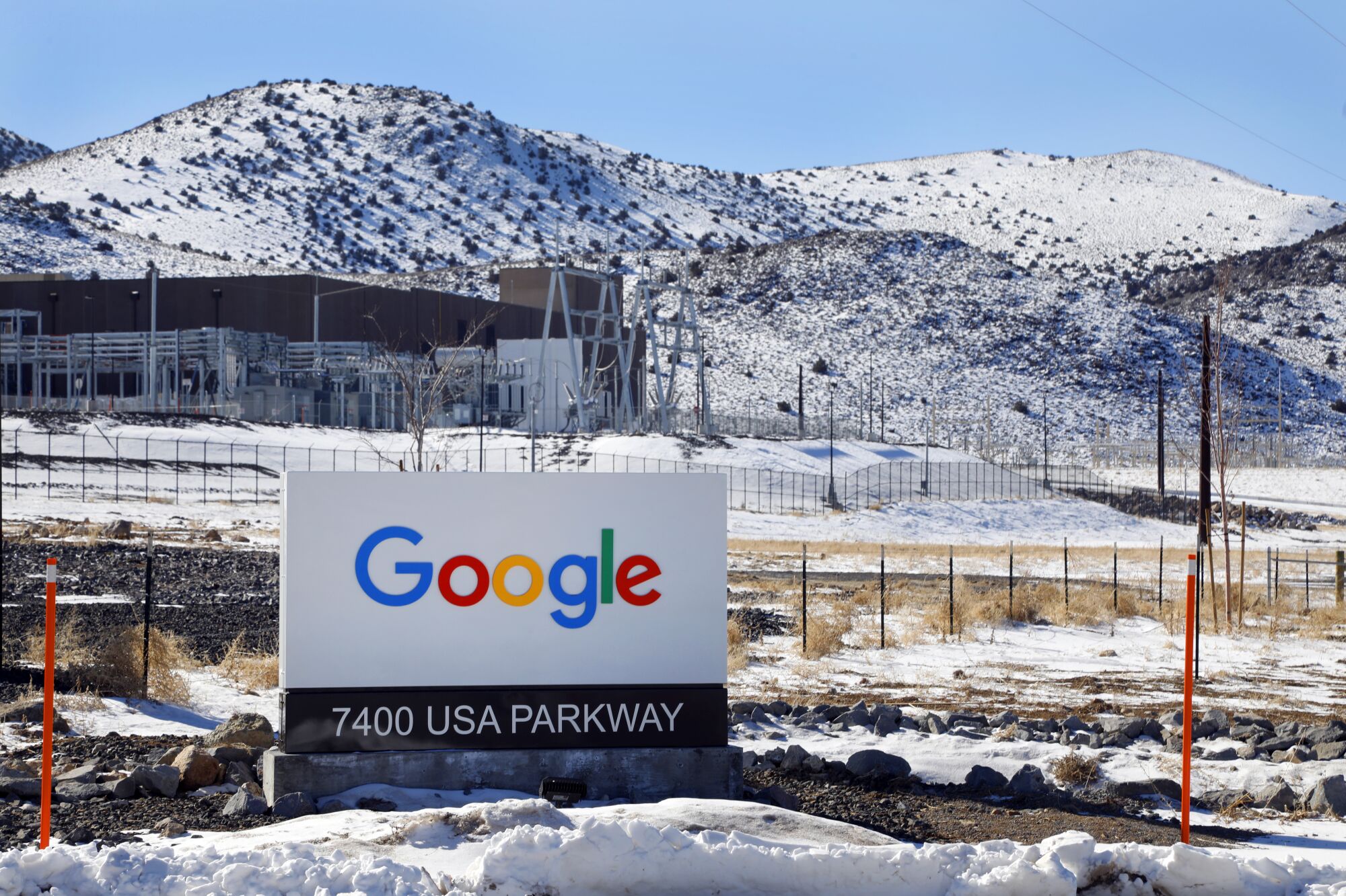 A Google sign in front of snowy mountains.
