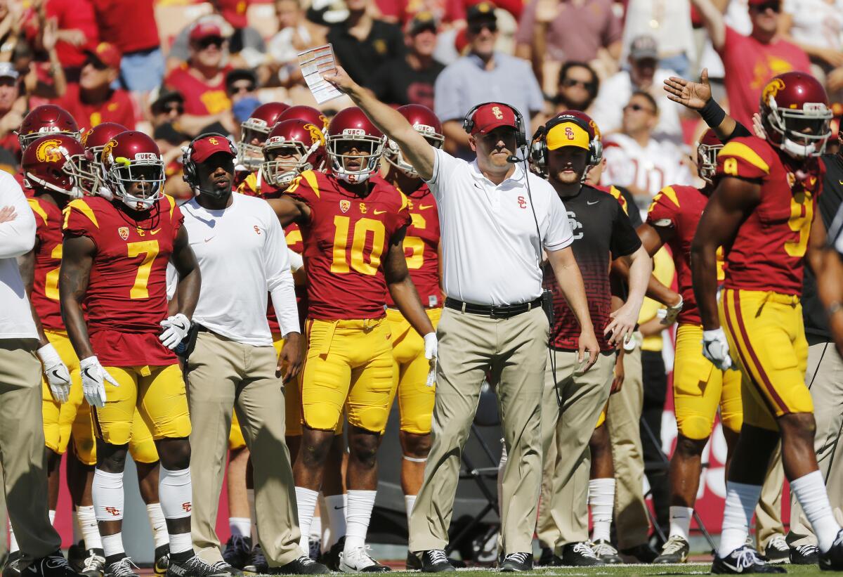 Trojans Coach Clay Helton signals a first down in the first half against Colorado on Saturday.