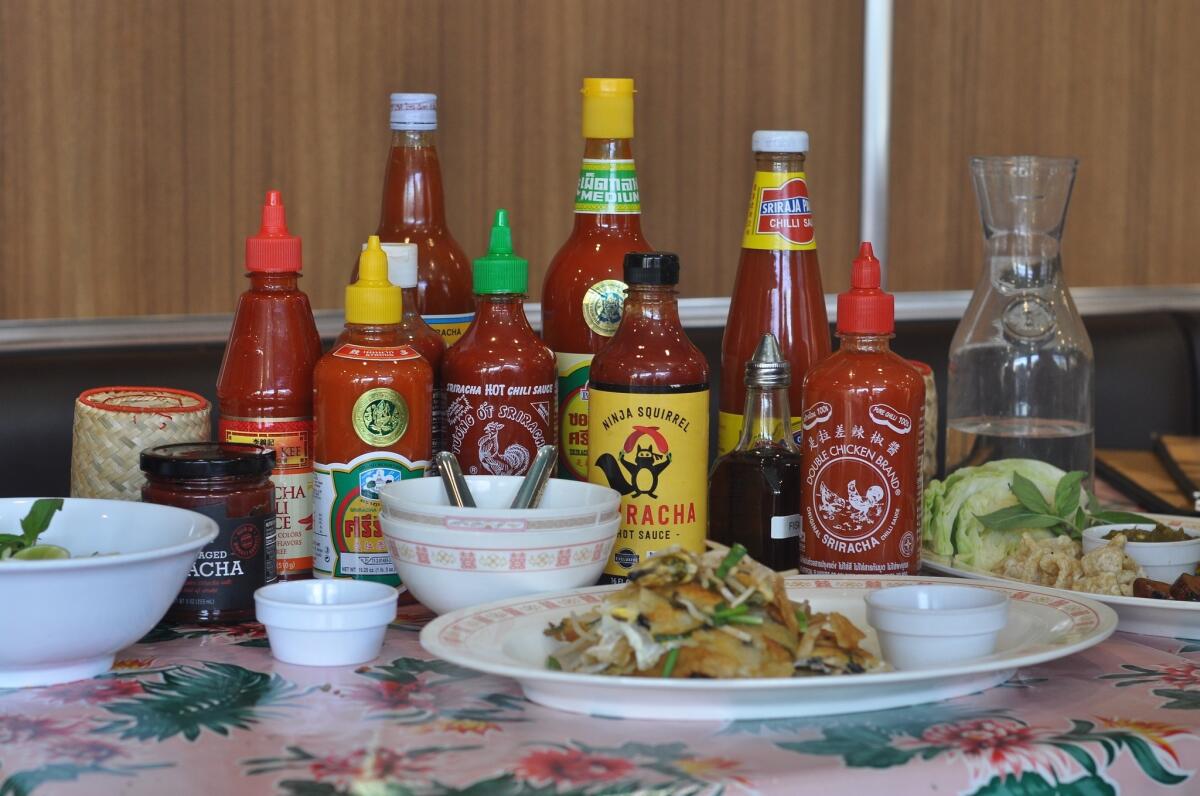 Bottles of Sriracha for sampling line the table at Pok Pok LA, Andy Ricker's Thai restaurant in Chinatown.