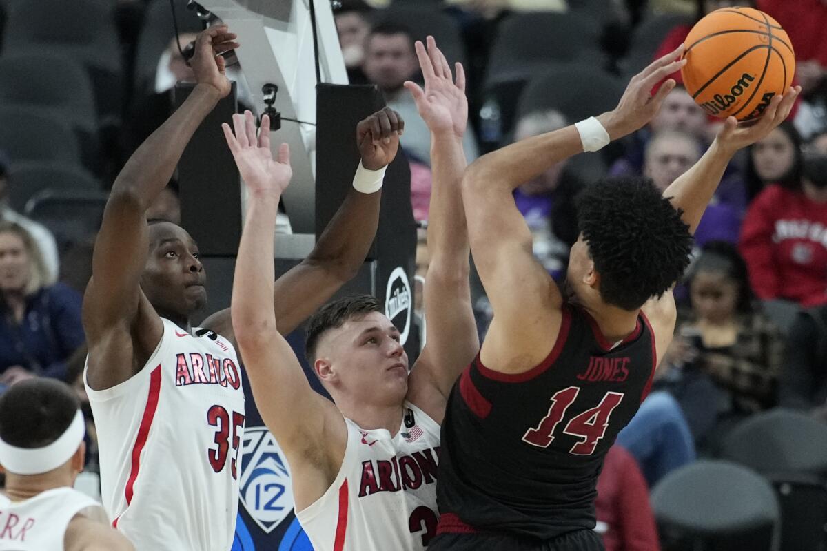 Arizona's Christian Koloko and Pelle Larsson guard Stanford's Spencer Jones.